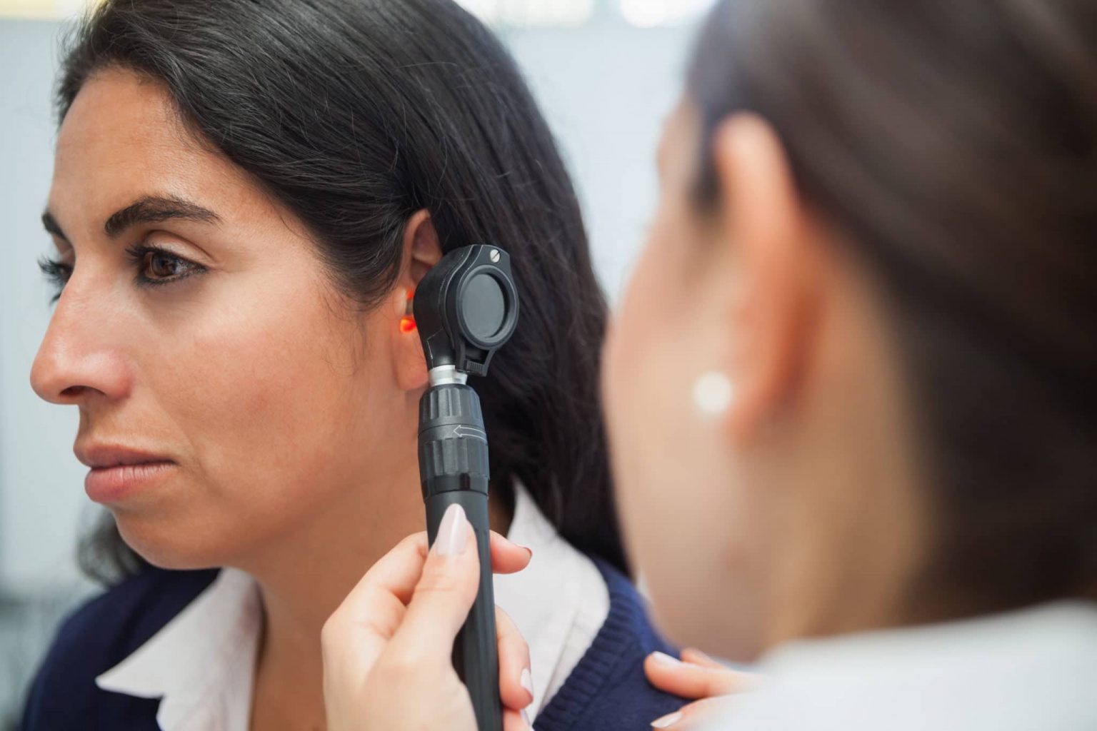 woman getting ear checked with otoscope by an ENT for Acoustic Neuruoma