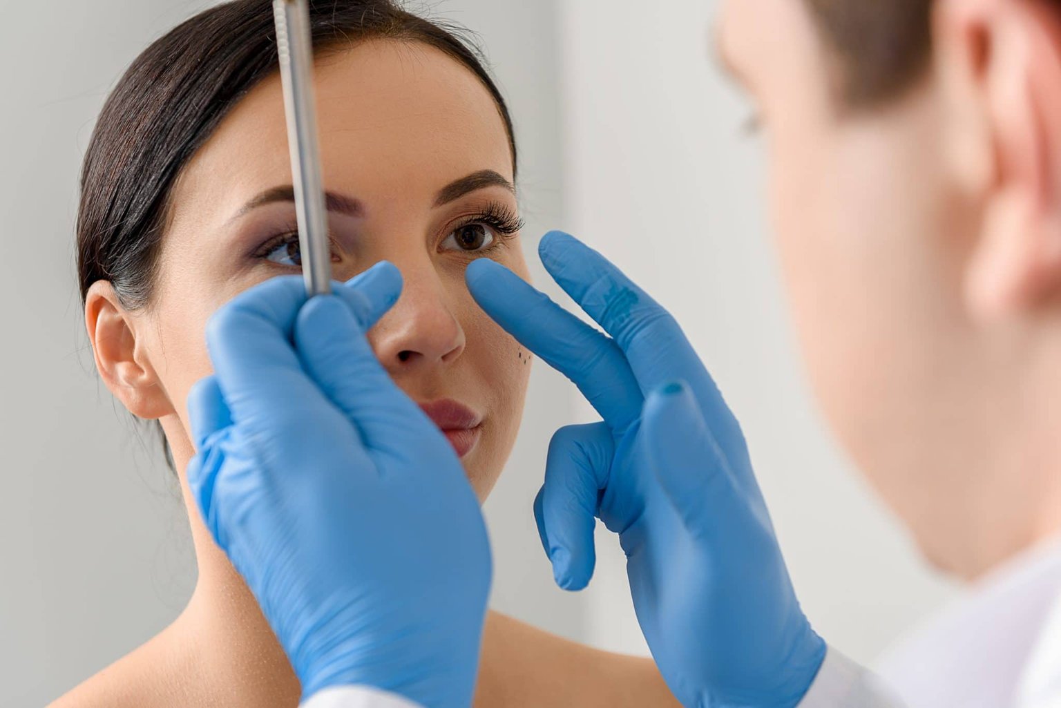 Doctor examining a patient before nasal surgery.